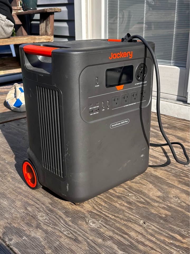 Jackery HomePower 3600 Plus on an owner's wooden deck with its charging cable connected