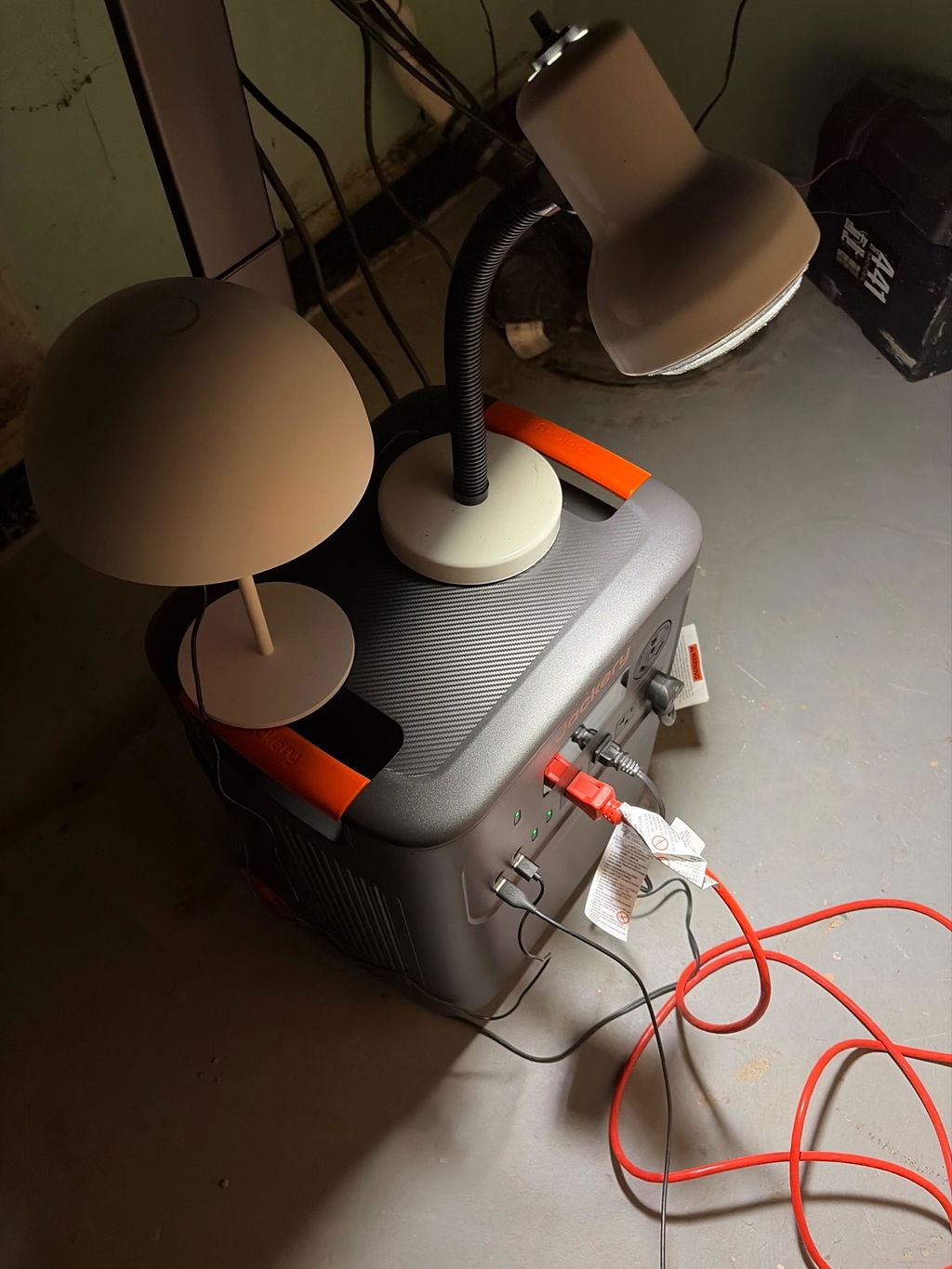Jackery HomePower 3600 Plus in a basement with a lamp and extension cords plugged in