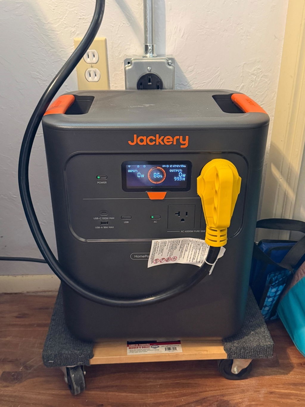 Jackery HomePower 3600 Pro Max at home on a rolling dolly with a heavy-duty power cable plugged in